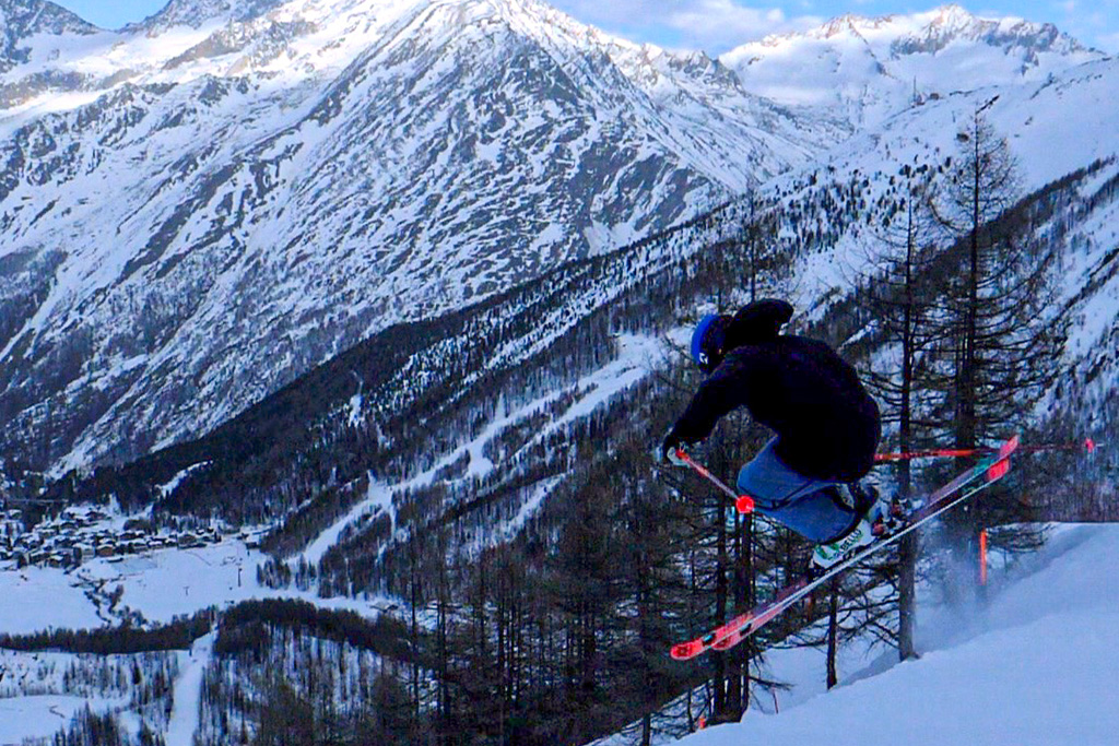 Skifahrer springt während Abfahrt ins Tal