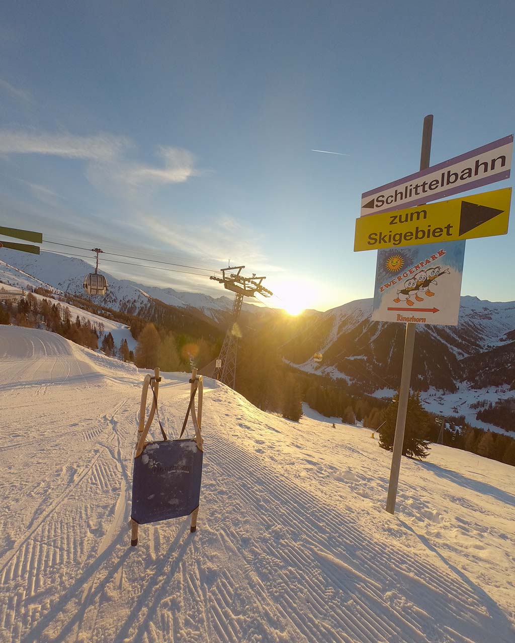 Schlitten steht im Sonnenuntergang auf Rodelbahn in Davos