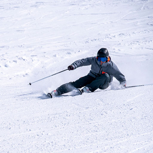 Skifahrer mit den Händen im Schnee beim Carven